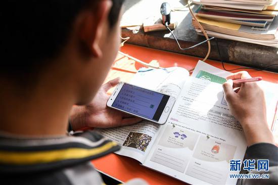  3月10日，內(nèi)蒙古準(zhǔn)格爾旗龍口鎮(zhèn)紅樹梁村的初一學(xué)生劉進才在家中上網(wǎng)課。&nbsp;新華社記者 劉磊 攝