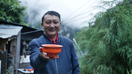  扎西巴珠展示他制作的木碗。新華網(wǎng) 旦增努布攝